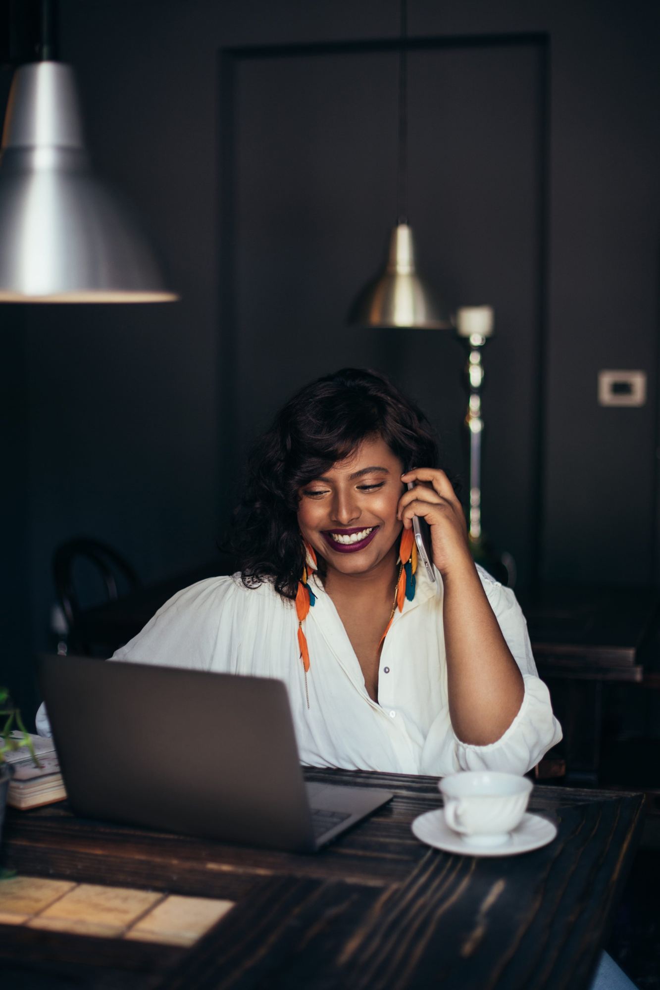 Woman smiling while talking on her mobile phone in a restaurant